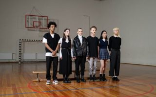 Stylish group of Gen Z friends standing in a gym, showcasing diverse fashion trends.